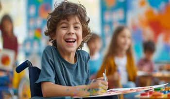 A happy young child in a wheelchair at school